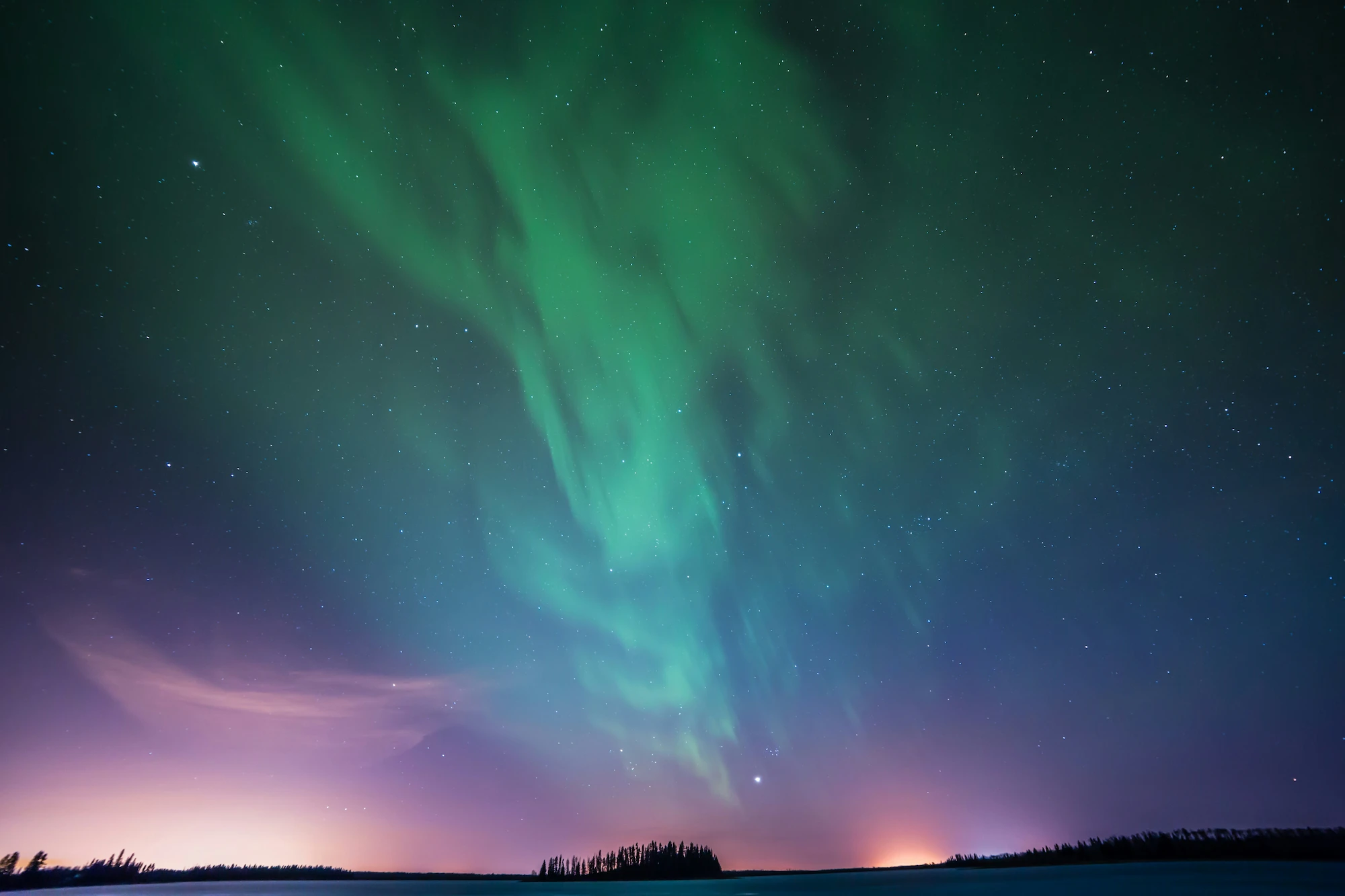 Night skiing across a frozen lake under the Arctic sky